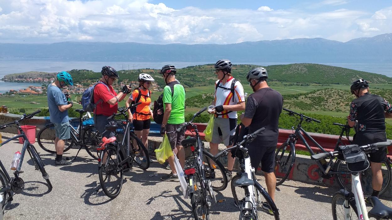 Eine Gruppe Radfahrende pausiert an einem Aussichtspunkt