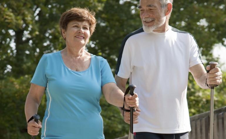 Ein älteres Paar beim Nordic Walking