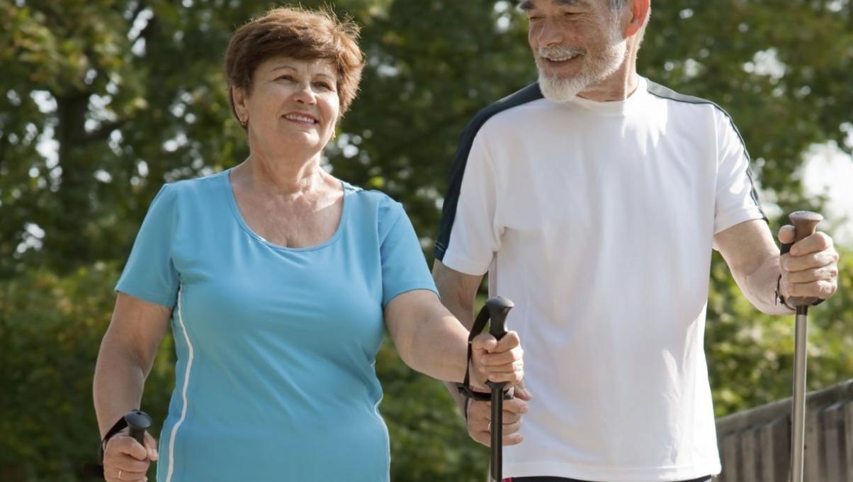 Ein älteres Paar beim Nordic Walking